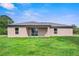 Tan house exterior with covered patio and grassy yard at 5389 Ulysses St, Port Charlotte, FL 33981