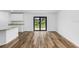 Spacious living room with wood-look flooring and sliding glass doors leading to the backyard at 12157 Shellnut Ave, Port Charlotte, FL 33981