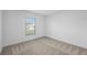Bright bedroom featuring neutral carpet and large window at 12169 Patterson Ave, Port Charlotte, FL 33981