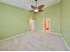 Bright primary bedroom featuring green walls, a ceiling fan, and ensuite access to a bathroom at 2220 Kings Palace Dr, Riverview, FL 33578