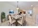 Dining room with a table set for six, modern chandelier, and an open view to the living room at 2220 Kings Palace Dr, Riverview, FL 33578
