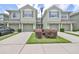 View of a two story townhome with garage, green shutters, landscaping and a double wide driveway at 2220 Kings Palace Dr, Riverview, FL 33578