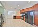 Well-equipped kitchen with wooden cabinets, black appliances, and tile flooring at 2220 Kings Palace Dr, Riverview, FL 33578