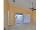 Bright living room with a vaulted ceiling, fan, and sliding doors to the outside balcony at 2220 Kings Palace Dr, Riverview, FL 33578