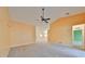 Large, sun-filled living room featuring neutral carpet and paint with a ceiling fan at 2220 Kings Palace Dr, Riverview, FL 33578