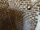 Shower with dark brick tile and a shower head at 103 W Hamilton Ave, Tampa, FL 33604