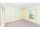 Bright bedroom features neutral carpet, a window for natural light, and a ceiling fan at 4787 Hamlets Grove Dr, Sarasota, FL 34235