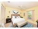 Sunny bedroom with a ceiling fan, a large window, and warm yellow walls at 4787 Hamlets Grove Dr, Sarasota, FL 34235