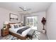 Serene bedroom with a ceiling fan, sliding glass doors, and minimalist decor at 4787 Hamlets Grove Dr, Sarasota, FL 34235