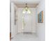 Entryway with light tile flooring, transom window, and modern lighting fixture at 4787 Hamlets Grove Dr, Sarasota, FL 34235