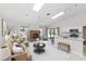 Bright, open living room features a brick fireplace, skylights, and seamless indoor-outdoor living at 4787 Hamlets Grove Dr, Sarasota, FL 34235