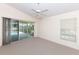 Carpeted main bedroom with ceiling fan and a sliding glass door leading to the pool at 4787 Hamlets Grove Dr, Sarasota, FL 34235