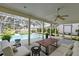 Relaxing covered patio with comfortable seating and views of the sparkling pool and lush landscaping at 4787 Hamlets Grove Dr, Sarasota, FL 34235