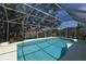 Sparkling pool with screened enclosure overlooks lush landscaping and a serene pond with fountain at 4787 Hamlets Grove Dr, Sarasota, FL 34235