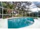 Sparkling backyard pool enclosed with a screen and overlooking the water view at 4787 Hamlets Grove Dr, Sarasota, FL 34235