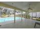 Covered patio area with ceiling fan overlooking a screened in in-ground pool at 4787 Hamlets Grove Dr, Sarasota, FL 34235