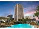Luxury high-rise building with a resort-style pool and waterfall at dusk at 449 S 12Th St # 2405, Tampa, FL 33602