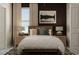 Bright bedroom with a queen bed, nightstands, and a large window at 10439 Lavender Aster Trl, San Antonio, FL 33576