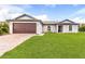 Single-story home with a two-car garage and landscaped lawn at 6007 Gillot Blvd, Port Charlotte, FL 33981