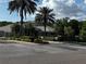 Beautiful Clubhouse featuring lush landscaping, brick signage and tall palm trees at 5016 Givendale Ln, Tampa, FL 33647