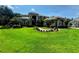An expansive lawn and walkway lead to an elegant home nestled amongst lush green landscaping and mature trees at 5016 Givendale Ln, Tampa, FL 33647