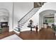 Grand foyer with staircase, hardwood floors, elegant lighting, and arched doorways at 5016 Givendale Ln, Tampa, FL 33647