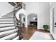 Elegant foyer with a curved staircase, dark wood floors, and a glimpse of the formal living room at 5016 Givendale Ln, Tampa, FL 33647