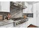 Modern kitchen featuring stainless steel gas range, granite countertops and hood at 5016 Givendale Ln, Tampa, FL 33647