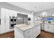 A bright kitchen features stainless steel appliances, a white island, and hardwood floors at 5016 Givendale Ln, Tampa, FL 33647