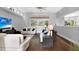 Bright living room with white sofas, hardwood floors, large windows, and overhead fan at 5016 Givendale Ln, Tampa, FL 33647