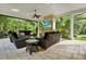 Comfortable screened-in living room featuring stone fireplace with a TV and lush outdoor views at 5016 Givendale Ln, Tampa, FL 33647