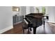 Living room featuring grand piano, hardwood floors, and custom cabinet for sophisticated living at 5016 Givendale Ln, Tampa, FL 33647