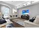 Bright living room features hardwood floors, white sofas, and a modern entertainment center at 5016 Givendale Ln, Tampa, FL 33647