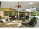 Comfortable screened-in living room featuring ample seating, a ceiling fan, and pool views at 5016 Givendale Ln, Tampa, FL 33647