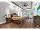 Spacious main bedroom with tray ceiling, dark wood furniture, and natural light at 5016 Givendale Ln, Tampa, FL 33647