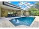Gorgeous screened-in pool with spa, fountain, adjacent outdoor kitchen, and dining area at 5016 Givendale Ln, Tampa, FL 33647