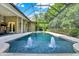 Gorgeous screened-in pool with spa and fountain water feature adjacent to outdoor kitchen and dining area at 5016 Givendale Ln, Tampa, FL 33647