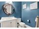 Stylish powder room with blue walls, ornate mirror, and modern white vanity at 5016 Givendale Ln, Tampa, FL 33647