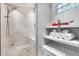 A walk-in shower features marble tile, a rain shower head, and a built-in bench at 5016 Givendale Ln, Tampa, FL 33647