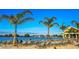 Beach area with lounge chairs and palm trees by the lagoon at 32088 Powderpuff Mimosa Dr, San Antonio, FL 33576