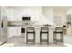 Modern kitchen with white cabinets, granite countertops, and island with seating at 32088 Powderpuff Mimosa Dr, San Antonio, FL 33576