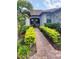 Brick walkway lined with lush green shrubs leading to the front entrance at 12831 Oriago St, Venice, FL 34293