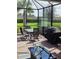 Screened patio with table, chairs, grill and fire pit at 12831 Oriago St, Venice, FL 34293