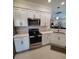 Modern kitchen with stainless steel appliances and white cabinets at 12831 Oriago St, Venice, FL 34293