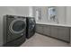 Laundry room with gray cabinets, washer, dryer and hexagon tile floor at 2905 W San Carlos St, Tampa, FL 33629