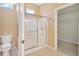 Bathroom featuring a glass enclosed shower, tiled floors, and a water closet at 8049 Sanguinelli Rd, Land O Lakes, FL 34637