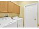 Bright laundry room with overhead cabinets, a washer, and a dryer at 8049 Sanguinelli Rd, Land O Lakes, FL 34637