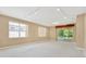 Bright living room features neutral carpet, track lighting, and sliding glass doors to a screened lanai at 8049 Sanguinelli Rd, Land O Lakes, FL 34637