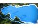 Aerial view of a large, crystal-clear lagoon with residents enjoying watersports at 10384 Honey Hammock Way, San Antonio, FL 33576