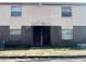 Exterior view of a light beige building with dark brown brick accents at 303 E Wellington Ct # 59, Tampa, FL 33604